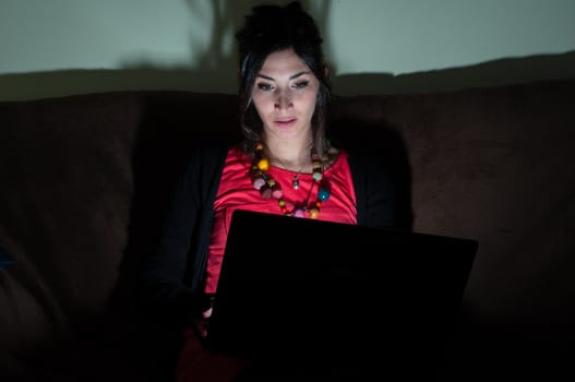 woman at home using notebook on couch