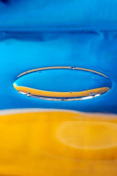 Macro photo of painted blue and yellow liquid with shallow depth of field. Natural colors and light 