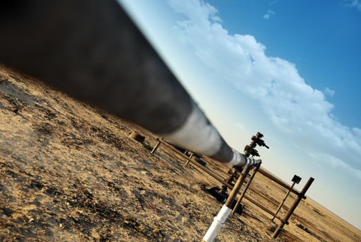 Old oil well in the desert and oil spills on soil