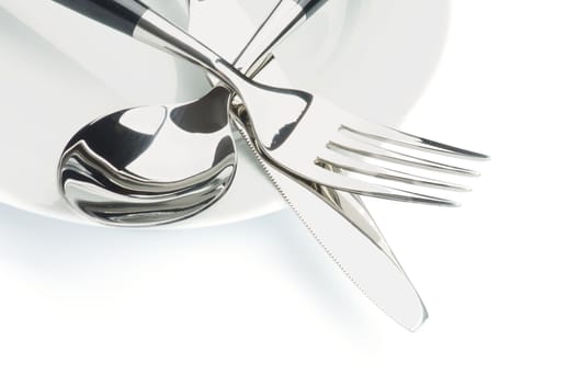 Arrangement of Silverware with Table Knife, Spoon and on White Plate isolated on white background