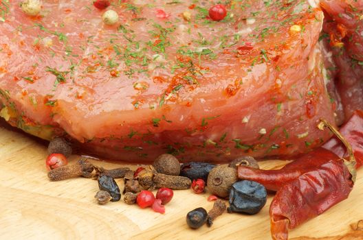 Marinated Raw Pork with Herbs, Dill and Spices closeup on Wooden Cutting Board