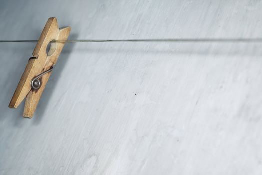 Close-up horizontal photo of the old wooden clothes pin hanged on a clothes-line