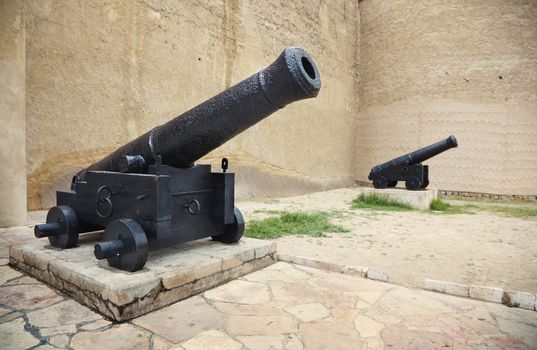 Two old guns on the carriages at the historical museum. Dubai, United Arab Emirates