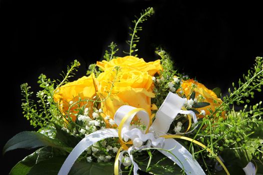 A bouquet of yellow flowers with a decorative white ribbon, close-up