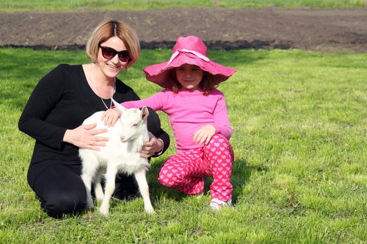 mother and daughter with little goat