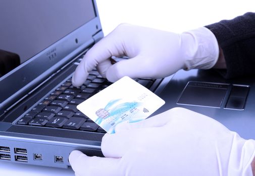 theif with protective glove online stealing with stolen credit card with a blue negitivity filter