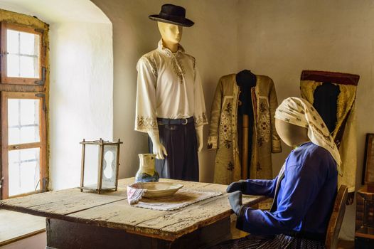 mannequins dressed in traditional clothes next to a window