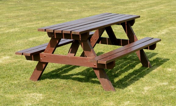 A park picnic table isolated on green grass background