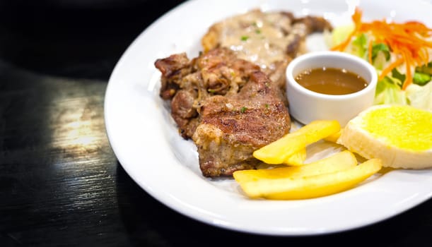 Pork Steak with sauce on white dish in restaurant