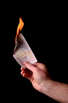 ten pound note burning isolated on black background