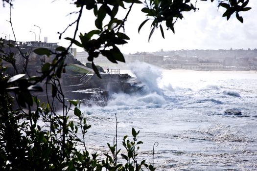 Powerful waves breaking in a cloud of spray on the shoreline at Bondi Beach in Sydney, Australia during a cyclone