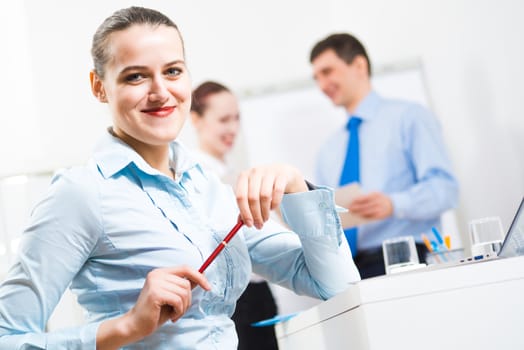 portrait of a business woman in office, smiling and looking into the camera, office work