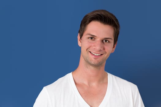 Portrait of a young man in front of a blue background