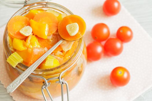 Glass jar with vegetables ragout and cherry tomatoes on the napkin