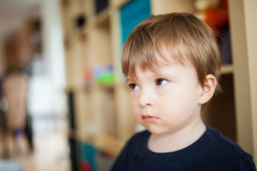 Sad little boy inside a house