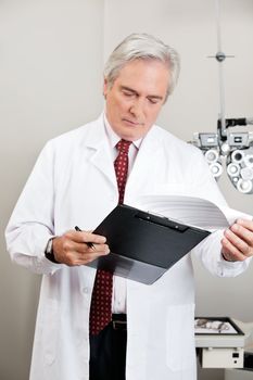 Busy optometrist checking the prescription in his clinic