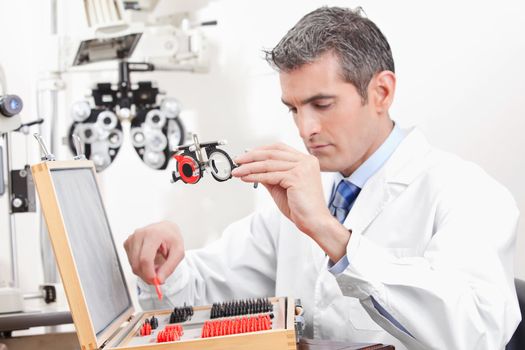 Optometrist looking at measuring eye glasses.