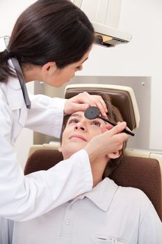 Optometrist doing sight testing for pateient.
