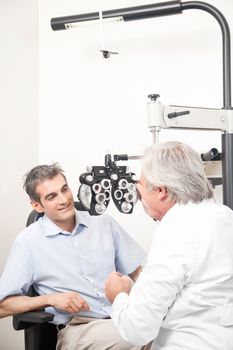 Optometrist doing sight testing for pateient.