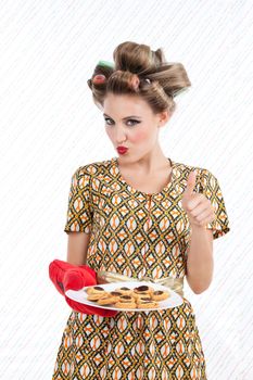 Woman with cookies giving thumbs up.