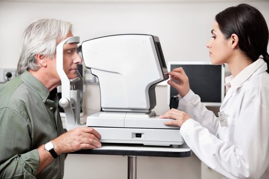 Young optometrist performing visual field test with an advance equipment