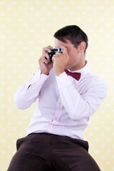 Portrait of retro styled male taking a photo with rangefinder camera
