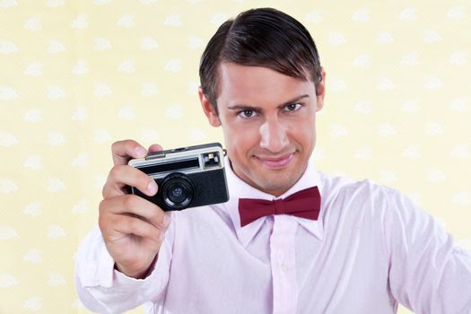 Male holding retro camera in hand - shallow depth of field, focus on camera