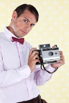 Portrait of a retro styled male holding a medium format antique film camera