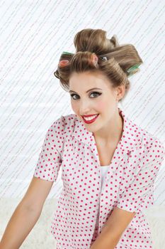 Portrait of an attractive young woman smiling with curlers in hair