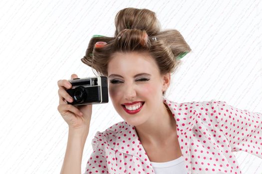 Portrait of retro styled attractive woman taking photo with 35mm camera