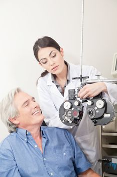Optometrist doing sight testing for pateient.