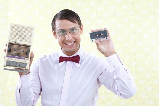 Man holding old audio cassette and player.