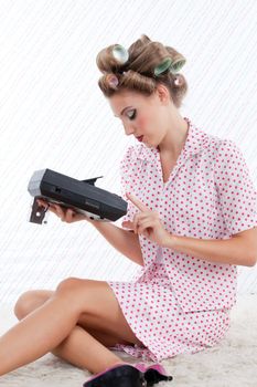 Woman with tape recorder sitting on rug.