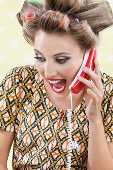 Young woman with hair curlers screaming out while holding a telephone