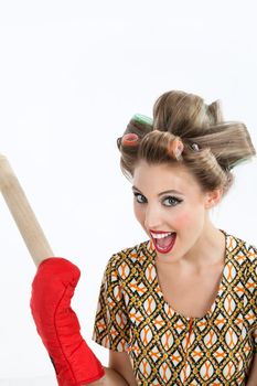 Portrait of pretty young woman with hair curlers screaming out while holding rolling pin over white background