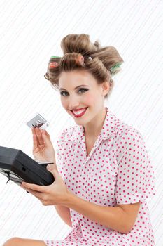 Retro styled woman holding tape recorder and cassette