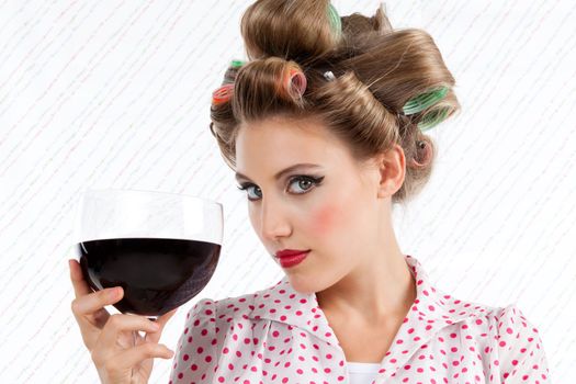 Attractive retro woman holding red wine glass looking at camera