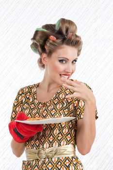Portrait of attractive retro woman eating cookings and looking at camera.