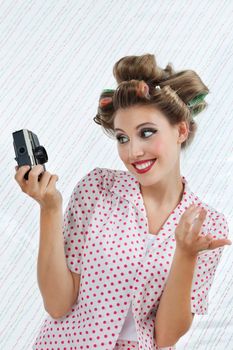 Beautiful young woman with hair curlers taking self portrait photograph through camera