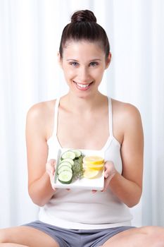 Young woman holding salad in tray.