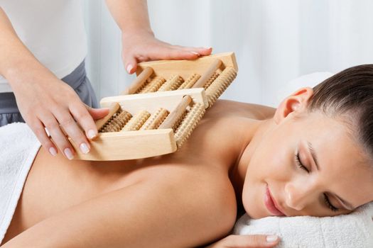 Relaxed young female receiving back massage by a female masseuse at health spa