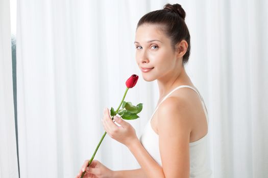 Young woman with a rose, indoors .