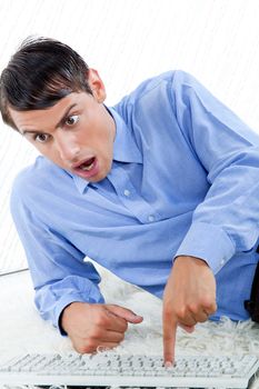 Surprised man with keyboard leaning on rug.