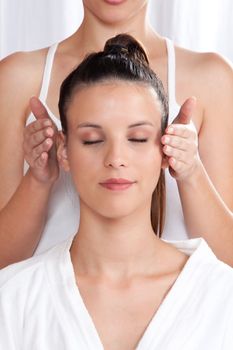 Woman receiving a head massage in spa.