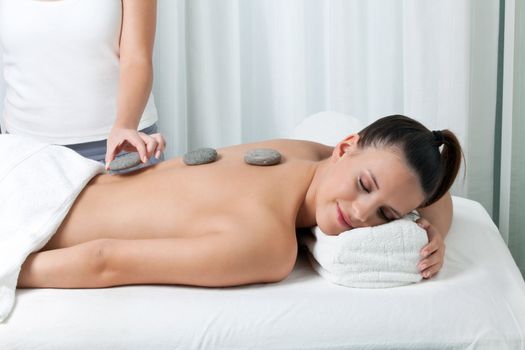 Woman receiving a stone massage in spa.