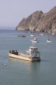 Big yellow transport supply ship moored on Santa Catalina Island in the quiet bay of Catalina Harbor