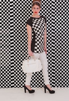 dressed young model with trendy Italian fashion in black and white and bag in hand