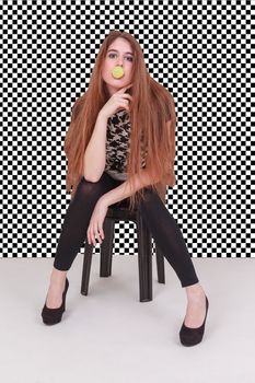 Girl with long hair makes bubbles with a bubble gum