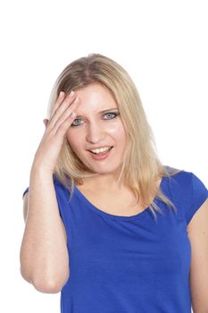 Beautiful blond haired woman in a blue dress holding her hand to her head with an anxious expression.