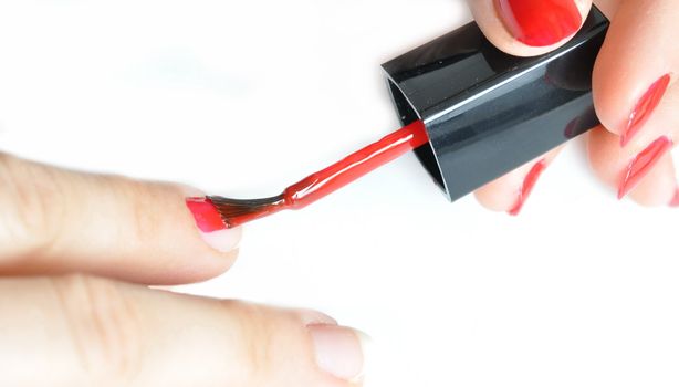Young girl painting her nails red